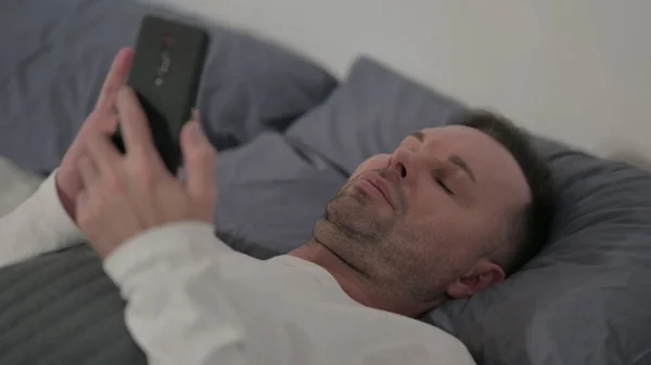 Close Middle Aged Man Using Smartphone While Laying Bed — Stockfoto