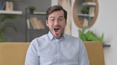Portrait of Beard Shocked Young Man Wondering in Awe at Home