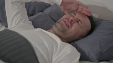 Close up Middle Aged Man having Headache while Sleeping in Bed