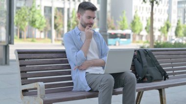 Thinking Man Using Laptop while Sitting on Bench