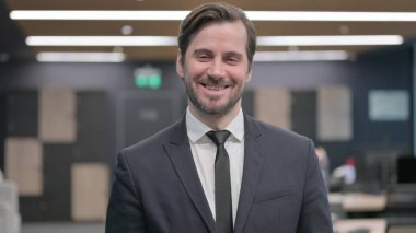 Kameraya gülümseyen genç iş adamının portresi