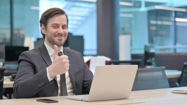 Young Businessman Showing Thumbs Sign While Using Laptop Office — Foto de Stock