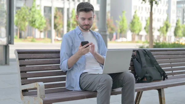 Man Using Smartphone Laptop While Sitting Bench — Stock fotografie