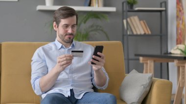 Sakallı genç adam Smartphone 'da online ödeme yapıyor.