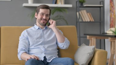 Sakallı genç adam Smartphone 'da konuşuyor