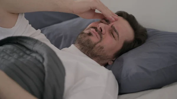 Jenggot Young Man Memiliki Sakit Kepala Sementara Tidur Tempat Tidur — Stok Foto