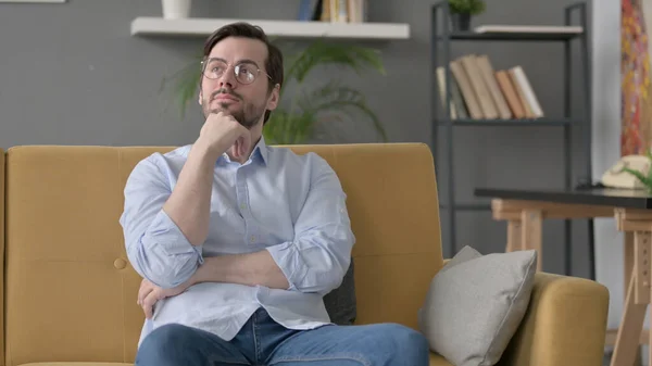 Barba Joven Pensando Mientras Está Sentado Sofá — Foto de Stock