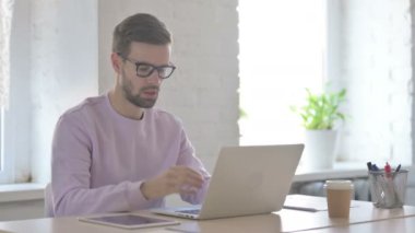 Genç Yetişkin Adam dizüstü bilgisayar kullanırken öksürüyor 