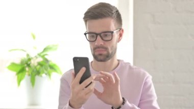 Genç Yetişkin Adam Smartphone 'da İnternet Taraması