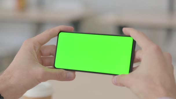 緑のクロマスクリーン付きスマートフォンで見る — ストック動画