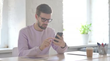 Genç Yetişkin Adam Ofiste Akıllı Telefon Kullanıyor 