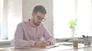 Genç Yetişkin Adam Ofiste Kağıda Yazıyor