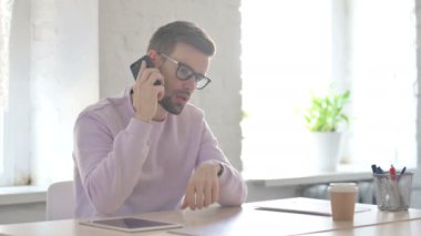 Üzgün Genç Yetişkin Adam Ofiste Akıllı Telefondan Öfkeyle Konuşuyor 