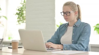 Ofiste dizüstü bilgisayar kullanırken Güzel Kadın Kameraya Bakıyor