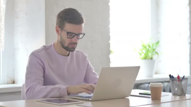 Młody Dorosły Mężczyzna Wskazuje Kamerę Podczas Korzystania Laptopa — Wideo stockowe