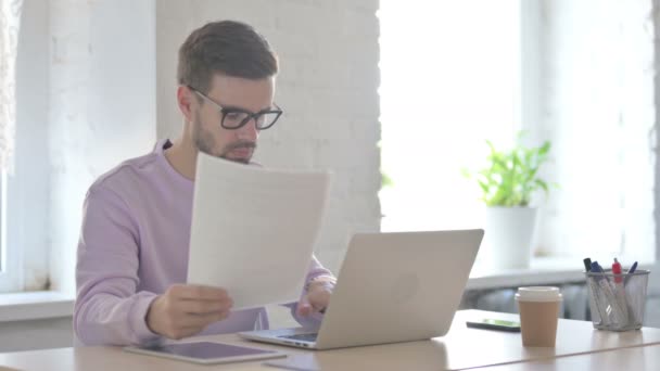Young Adult Man Doet Papierwerk Laptop Office — Stockvideo
