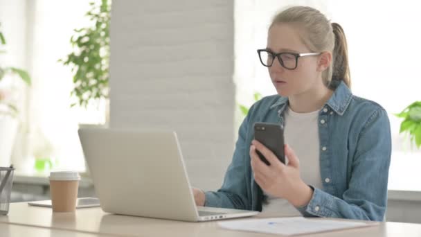 Bella Donna Che Utilizza Smartphone Durante Utilizzo Del Computer Portatile — Video Stock