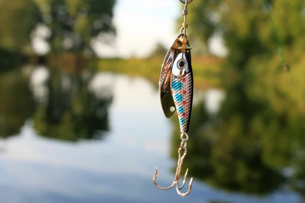 Señuelo de pesca sobre el fondo verde —  Fotos de Stock