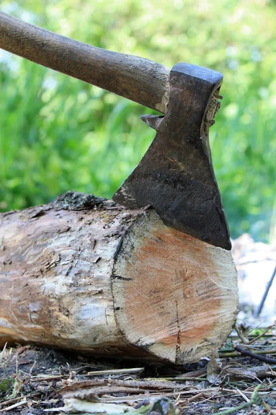 Ax en un tronco en el fondo de la hierba verde — Foto de Stock