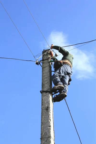 Electrician working on electric power pole — Stock Photo, Image