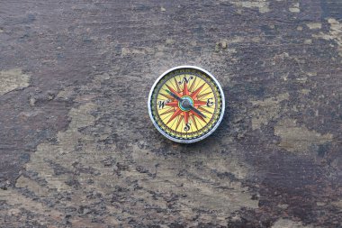 Pusula ile turizmin sembolü olarak doğal ahşap arka planda yuvarlak pusula, pusula ile seyahat ve pusula ile açık hava aktiviteleri