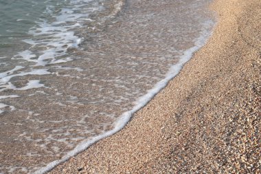 Güzel deniz dalgaları ve sahilde deniz suyu ve deniz köpüğü ile güzel bir deniz manzarası.