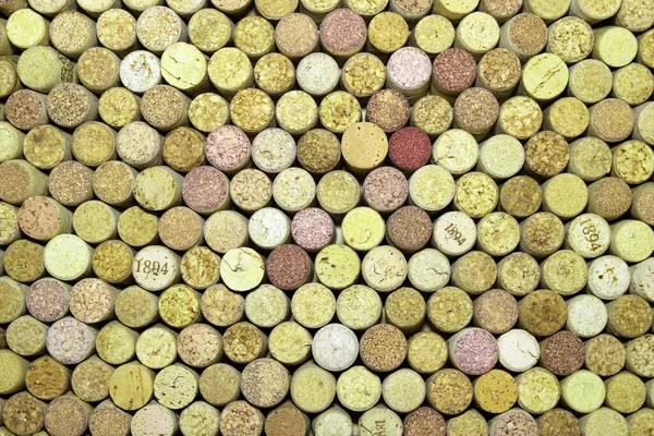 Abstract background of used red wine corks and white wine corks with corkscrew marks on corks and calendar dates on some corks