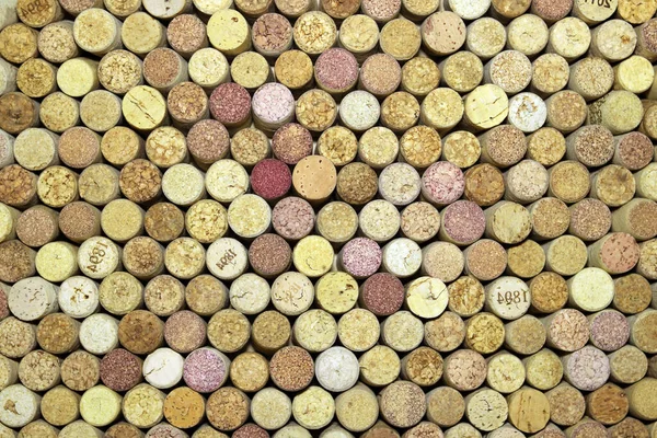 Abstract background of used red wine corks and white wine corks with corkscrew marks on corks and calendar dates on some corks