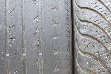 Old summer tire next to winter old tire as example of worn out summer tires and winter tires