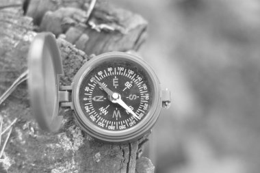 Pusula ile turizmin sembolü olarak siyah ve beyaz fotoğraf, pusula ile seyahat ve pusula ile açık hava aktiviteleri