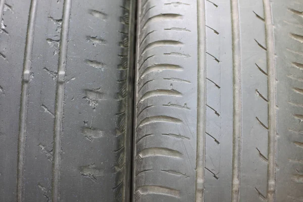 Old summer tire next to another old summer tire and worn tire next to smooth old tire close-up