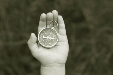 Pusula ile turizmin, pusula ile seyahat etmenin ve pusula ile açık hava aktivitelerinin sembolü olarak, doğal arka planda eski klasik navigasyon pusulası bulunmakta
