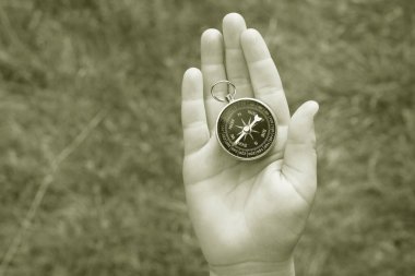 Pusula ile turizmin, pusula ile seyahat etmenin ve pusula ile açık hava aktivitelerinin sembolü olarak, doğal arka planda eski klasik navigasyon pusulası bulunmakta
