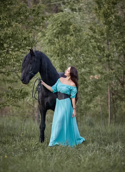 黒馬の横にあるドレスの美しい長髪の女の子 — ストック写真