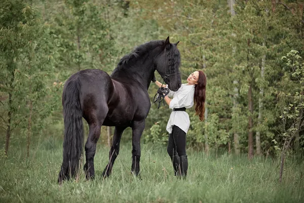 Hermosa Chica Pelo Largo Con Caballo Frisón Imágenes de stock libres de derechos