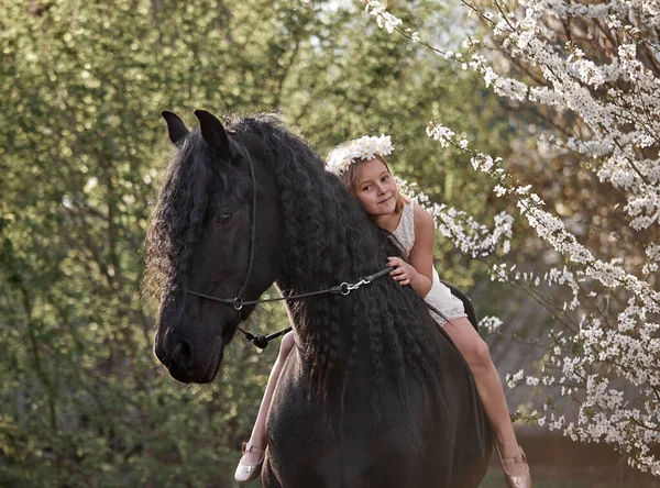 美しいです女の子とともに白い髪で春の花輪に乗ってフリジアの馬 — ストック写真