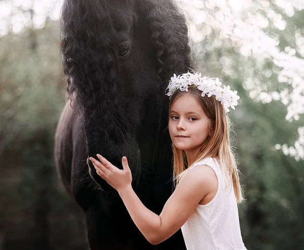 庭の春の花輪の白い髪をした美しい女の子は馬と一緒に — ストック写真