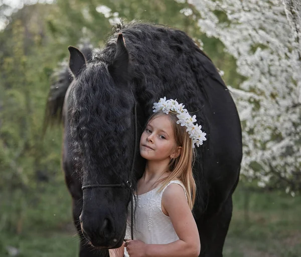 庭の春の花輪の白い髪をした美しい女の子は馬と一緒に — ストック写真