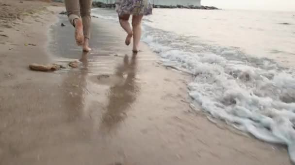 日の出のビーチでの日付恋人たちはビーチに沿って走ります — ストック動画