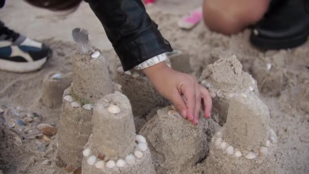 Η μαμά και ο γιος περπατούν μαζί στην φθινοπωρινή παραλία χτίζοντας ένα κάστρο στην άμμο. — Αρχείο Βίντεο