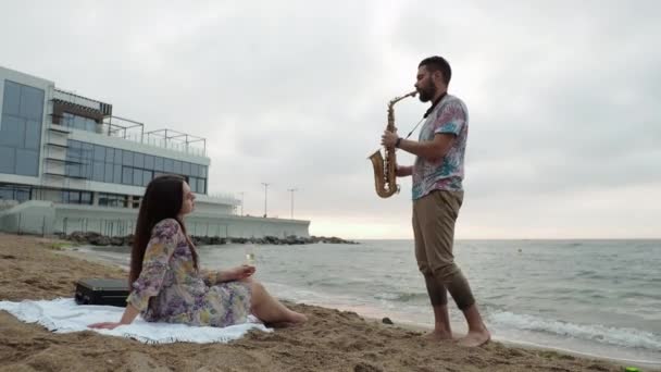 Datum till sjöss i gryningen picknick En man utför en serenad för sin älskade — Stockvideo
