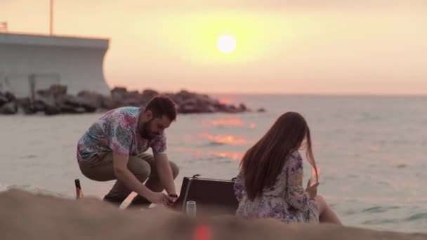 日付に海で夜明けピクニック男は彼の最愛のためのセレナーデを実行します — ストック動画