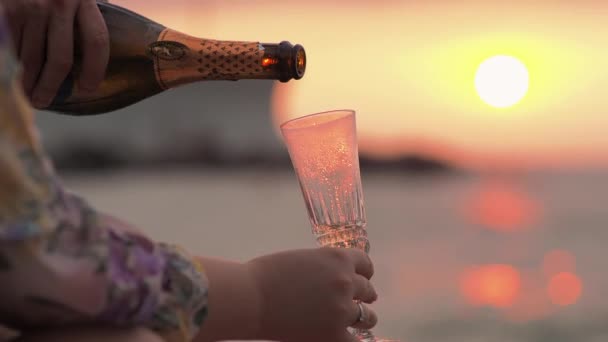 Ein Mann öffnet Champagner vor dem Hintergrund der Sonne Dawn liegt auf dem Bett. Picknick-Datum. — Stockvideo