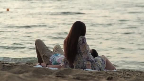 夜明けの海での日付太陽の下でピクニック愛好家は戻って海の風を楽しむ — ストック動画