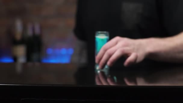 Μπάρμαν είναι ένας νεαρός άνδρας ρίχνει ποτά, ετοιμάζει αλκοολούχα σφηνάκια Μέδουσα στο μπαρ Σερβίρισμα του επισκέπτη ένα ποτό — Αρχείο Βίντεο
