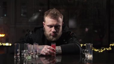 Portre adam sarhoş, alkollü içki içiyor ve bilincini kaybediyor. Sarhoş olup sızmış.