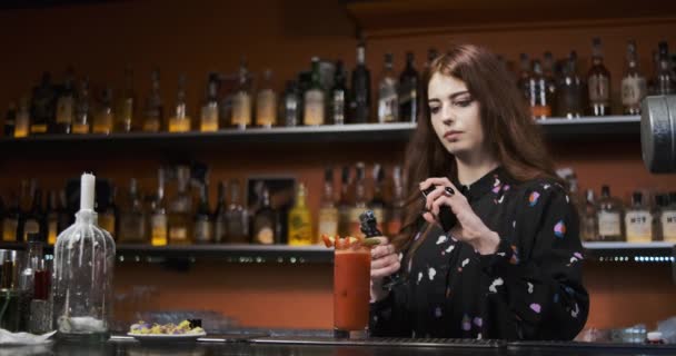 Roodharige meisje jong volwassen vrouw barman bereidt mixen bloederige vrolijke cocktail in de bar brand show — Stockvideo