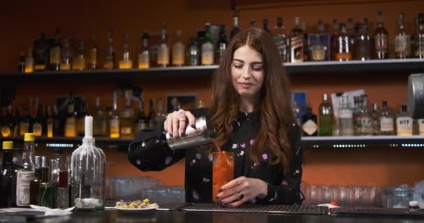 Roodharige meisje jong volwassen vrouw barman bereidt mixen bloederige vrolijke cocktail aan de bar — Stockvideo
