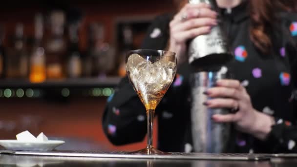 Rödhårig flicka ung vuxen kvinna bartender förbereder blandar papper flygplan cocktail bar häller is klockor — Stockvideo