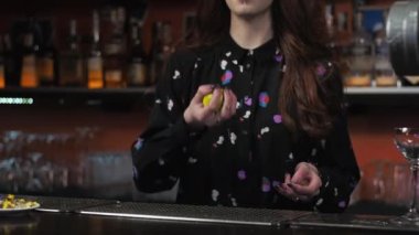 Geçiş hareketi. Kızıl saçlı kadın barmen margarita kokteyli hazırlıyor. Limon fırlatıyor.